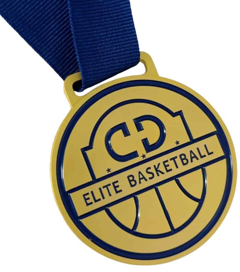 A custom gold die-cast medal for an elite basketball team. It features a blue soft enamel infill with the letters 'CD' and the words 'Elite Basketball' in raised gold metal. A blue ribbon is attached.