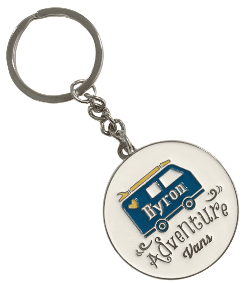 Circular custom metal keyring for a motoring travel company. It features a raised enamel logo of van and lettering, along with a white background.