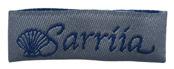 Silver custom woven label with a blue logo for use as a clothing label.