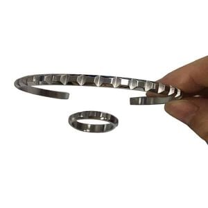 A slimline stainless steel bracelet with a unique shape formation around the outer side.