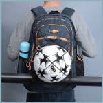 Review view of a soccer and basketball sports backpack. This image shows a soceer ball held securely into the back of the backpack.