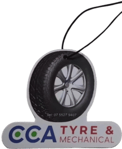 Custom-shaped air freshener for 'CCA TYRE & MECHANICAL', featuring a realistic die-cut car tyre and wheel at the top with 'Tel: 07 5527 9407' printed on it. Below the tyre is a light-coloured bar with the 'CCA' logo (green and blue circles), 'TYRE &' in dark blue/black, and 'MECHANICAL' in red. A black hanging string is attached.