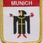 Sew on embroidered patch with MUNICH spelt in white at the top.