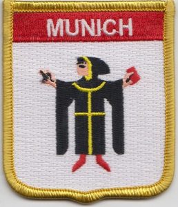 Sew on embroidered patch with MUNICH spelt in white at the top.