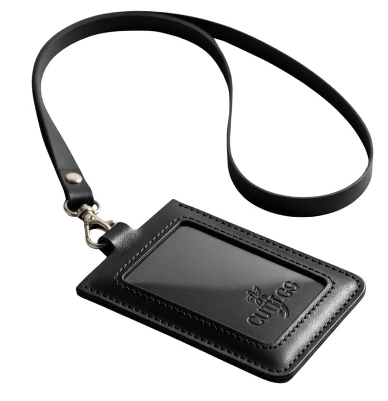 A professional studio shot of a custom black leather ID holder with a debossed logo, shown on a grey background.