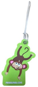 A personalised rubber luggage tag in the shape of a cartoon monkey on a bright green background.