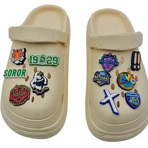 A pair of beige clog-style shoes decorated with custom personalised shoe charms, demonstrating the perfect size and fit for sports teams and school fundraising merchandise.