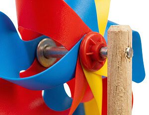A macro close-up of the durable plastic pin mechanism connecting the colourful windmill blades to the wooden handle.