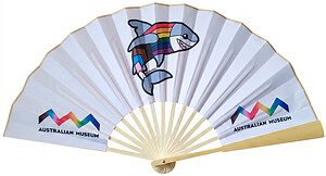 A custom-printed bamboo paper hand fan featuring the Australian Museum logo and a cartoon shark with a rainbow pride flag design.
